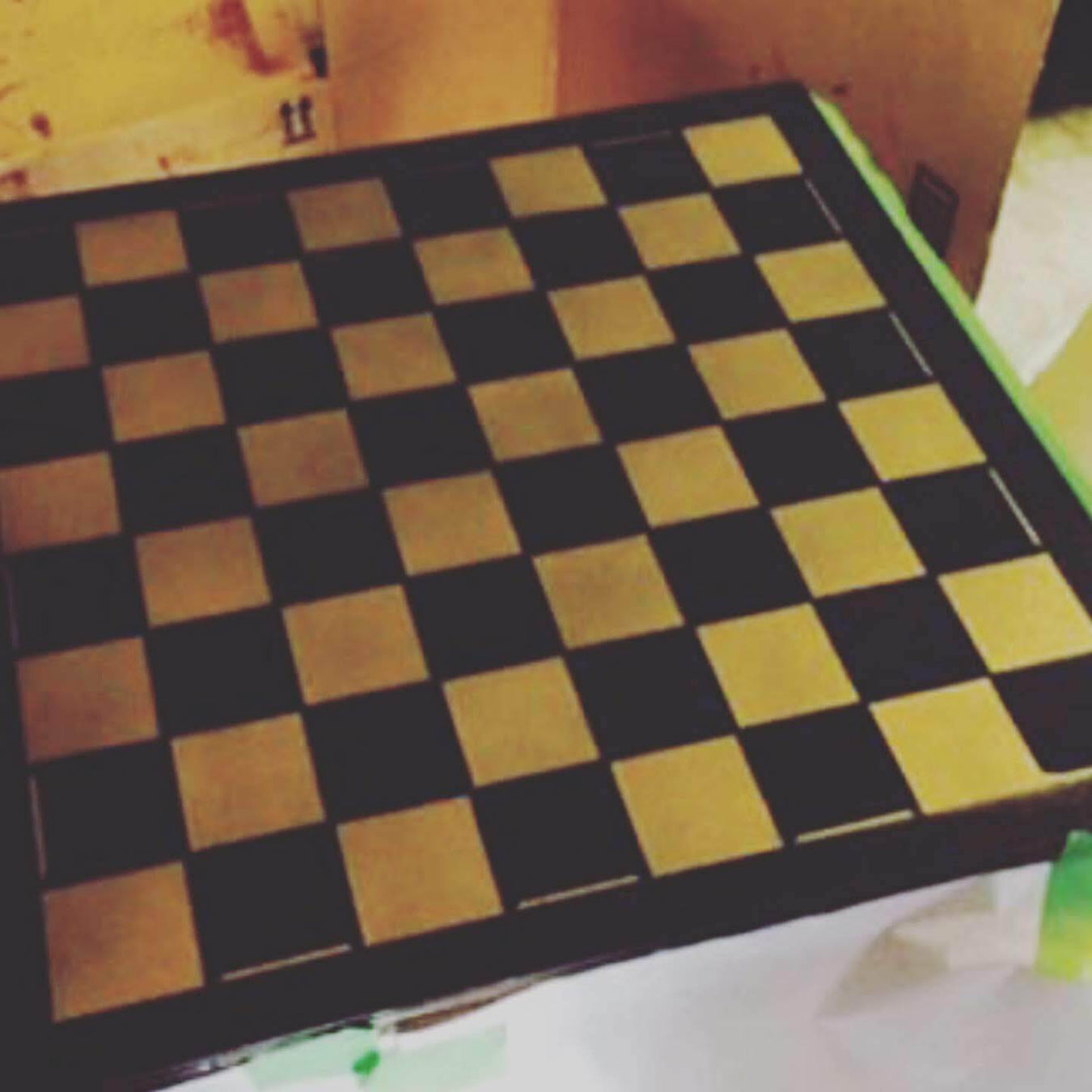 checkered chessboard pattern painted on a square table using paint stencil