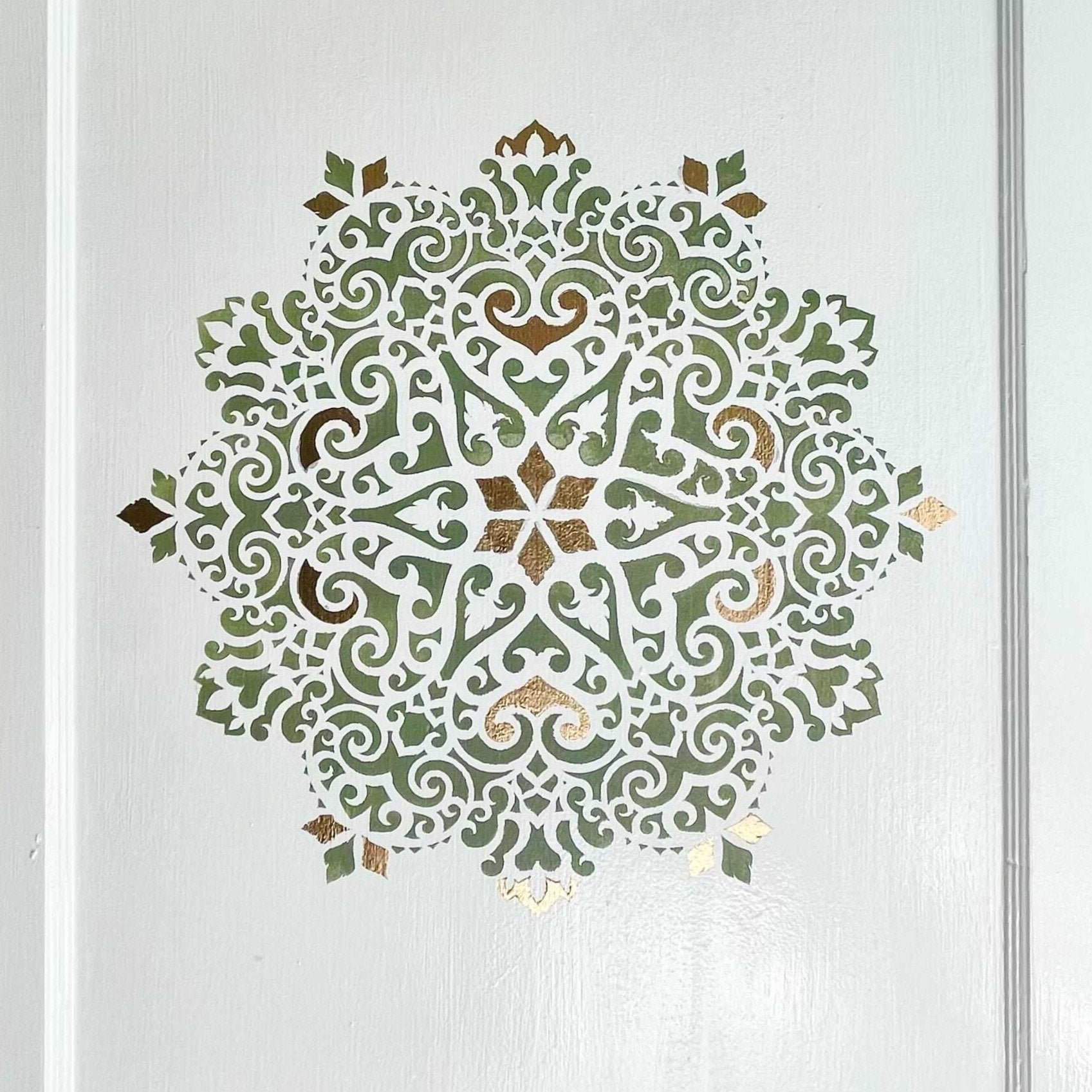 intricate mandala design painted on wall using paint stencil