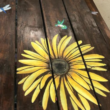 yellow daisy flower and bugs painted on wooden table using paint stencil